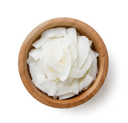 Coconut flakes, chips in a wooden plate close-up on a white. Top view