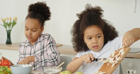Fototapeta premium Children and parents cook together in a modern kitchen, fostering creativity and teamwork