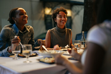 Friends enjoying dinner together at restaurant, laughing and talking