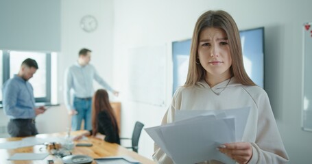 Fototapeta premium A Focused Woman Engaged in a Meeting with Her Colleagues Passionately Discussing Detailed Reports
