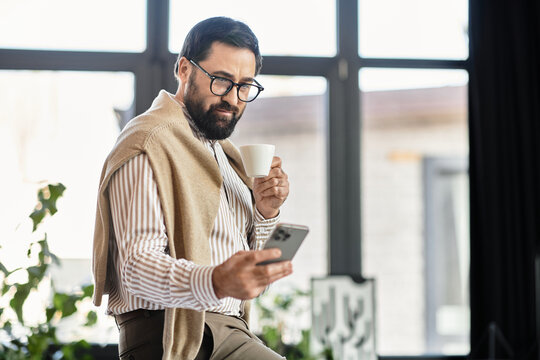 Elegant senior man enjoying coffee while browsing on his smartphone in a bright modern cafe