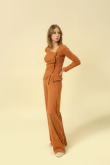 Fototapeta premium Studio photos of female model wearing basic comfortable knitted golden brown set, fall winter fashion collection.
