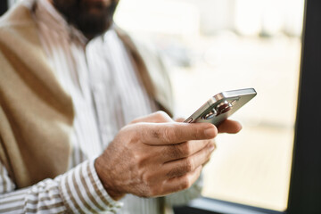 Elderly man engaged with smartphone while enjoying a moment of leisure in a cozy cafe