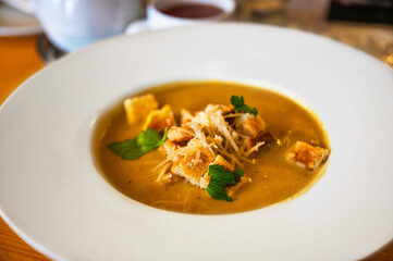 Pumpkin soup with grated cheese with fried bread cube, portion