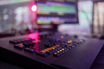 Closeup image of a hand mixing sounds on a control board, showcasing an audio technicians work