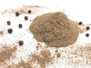 Spicy pile of pepper powder and little seeds on a white background.