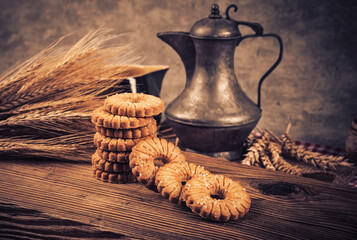 Oatmeal cookies and wheat ears on wooden table. Toned.