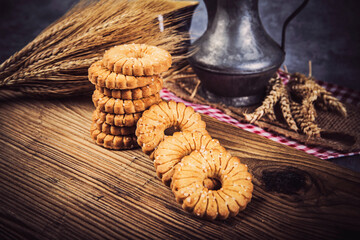 Oatmeal cookies and wheat ears on wooden table. Toned.