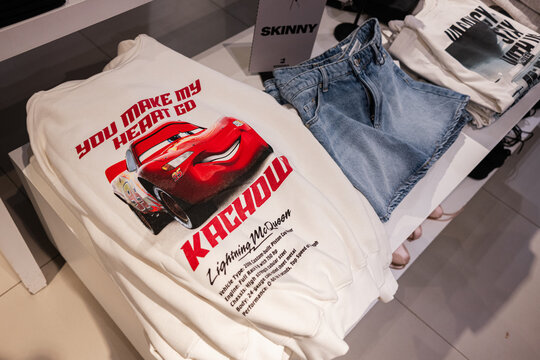 White sweatshirt with printed Lightning McQueen design displayed on a clothing store table