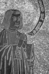 Engraved medieval tombstone with praying figure.