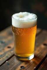 A Refreshing Glass of Golden Beer with a Creamy Head Resting on a Rustic Wooden Table