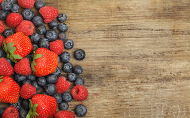 Organic fruit food background with red strawberry, raspberry and blueberry