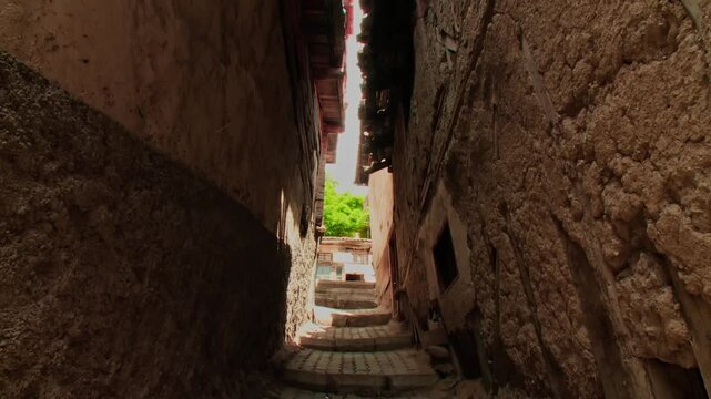 narrow street between adobe houses