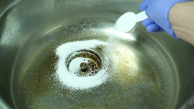 Cleaning the kitchen metal sink from plaque and lime deposits using Sodium percarbonate powder and hot water. Chemical reaction.
