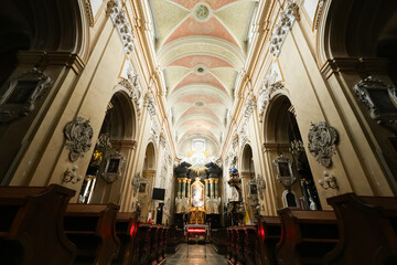 The interior of the Basilica of St. Michael the Archangel on Skałka in Kraków, Poland, showcases magnificent Baroque architecture, adorned with intricate gold detailing, frescoes, and religious iconog