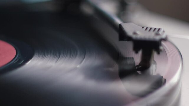 vinyl record player in which the vinyl record rotates and plays the composition close-up, the needle of the pickup on the vinyl record macro