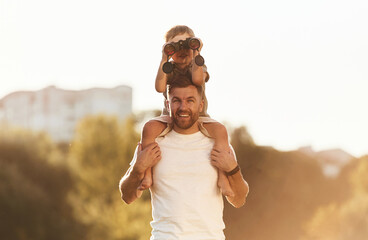 Binocular in hands. Father and son are together on the field