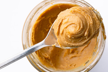 Delicious and healthy peanut butter on white background