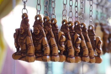 A set of keychains featuring small, tan-colored figures of a deity, likely Shiva, hanging from...