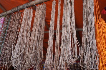 Multiple strands of Tulsi Kanthi Mala beads hanging for sale, these beads, often used for...