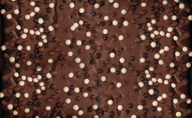 Chocolate brownie cake texture background sprinkled with white and dark balls, brounie banner
