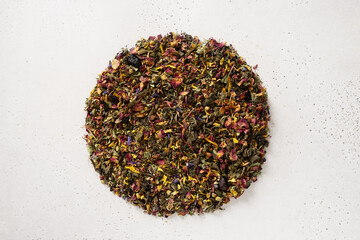 Pile of dry herbal tea and flowers green tea in shape of circle on white background. View from...