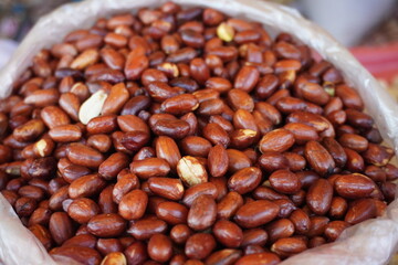 Obraz premium A pile of roasted spicy peanuts are displayed in a market setting likely for sale