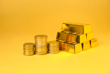 Gold bars and coins on golden background, closeup