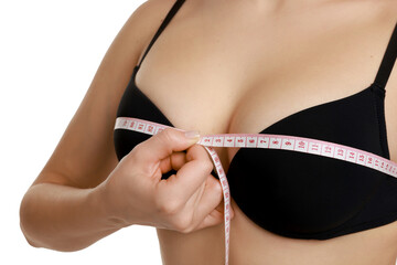 Woman in beautiful bra measuring breast circumference on white background, closeup