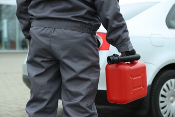 Man with canister near car outdoors, closeup