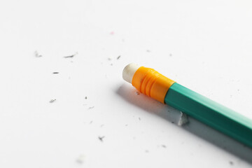 Obraz premium Pencil with eraser and scraps on white sheet of paper, closeup