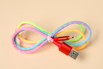 One USB charge cable on beige background, closeup