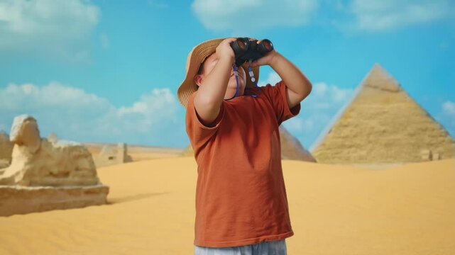 Asian Boy With A Hat Standing Doubtfully And Asking Why After Looking Through The Binoculars. Boy Researcher Examines Something While Traveling In Giza Pyramid, Travel Tourism Adventure Concept