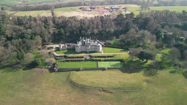 Famous Bolesworth Castle drone anti-clockwise rotate from far in spring sunshine - Cheshire, England, UK