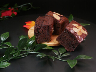 Dark chocolate brownies with crunchy almond topping slices, showing the details and depth of the...