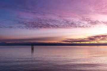 Fototapeta premium Serene coastline view captures the stunning colors of the sunrise at Oyster Bay Shoreline Park
