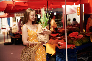 Young woman is on the vegetable market or bazaar