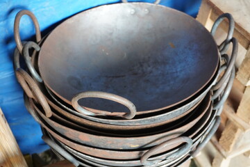 A stack of iron kadai cooking pots, essential in Indian kitchens