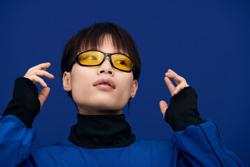 Attractive young asian man showcases trendy sunglasses while striking a dynamic pose in urban style