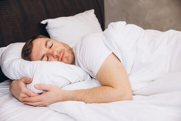 Man Sleeping Peacefully in Comfortable Bed, Hugging Pillow