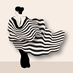 A woman wears a black backless gown adorned with flowing striped capes.