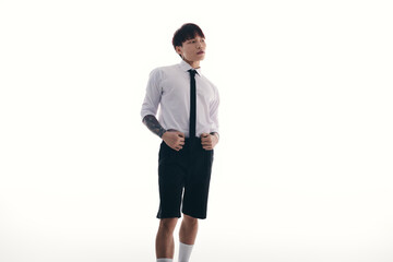 Stylish young man in a modern outfit showcasing confidence and charm in a minimalist setting