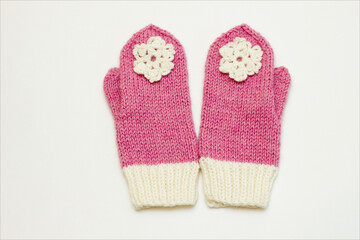 Handmade mittens tied from wool yarn by caring grandmother's hands. Handmade accessories. Mittens with snowflakes. Knitting as a way to relax and earn money.
