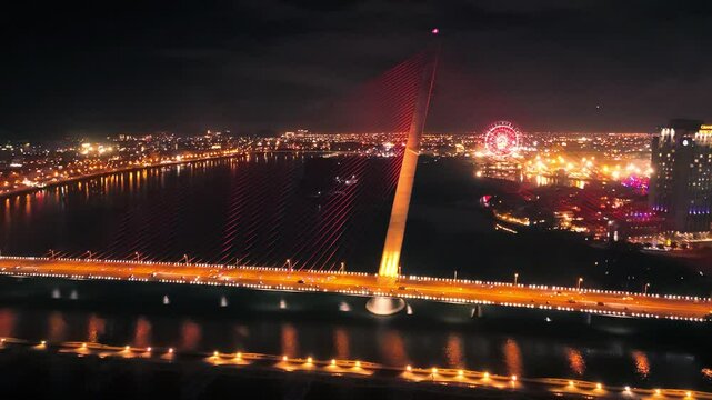 Tran thi ly bridge with its striking red cables illuminating the skyline of da nang, vietnam, creating a mesmerizing nightscape reflecting in the han river