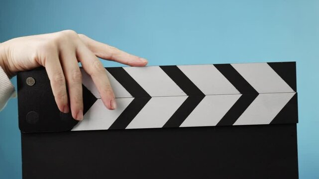 Cinema production process, closeup of a hand holding a clapboard, marking a video shoot