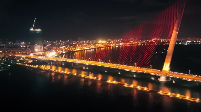 Tran thi ly bridge arching gracefully over han river, red suspension cables gleaming against nocturnal da nang skyline, highlighting architectural elegance and urban vibrancy