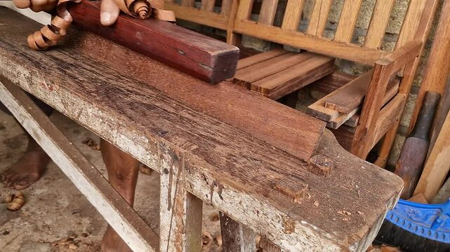 Hands of a carpenter planed wood, workplace