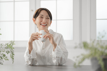 コーヒーカップを持つ女性