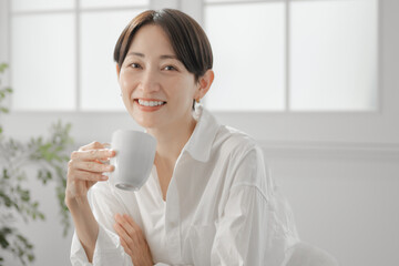 コーヒーカップを持つ女性