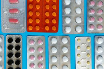 pharmacy colorful medicament pills and tablets in blisters on blue background